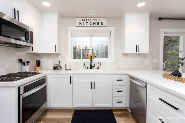 a kitchen with stainless steel appliances white cabinets and a sink