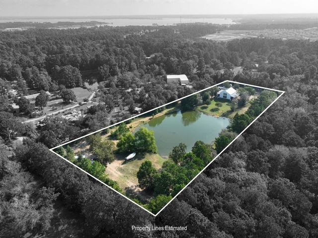 an aerial view of a house with a garden and lake view
