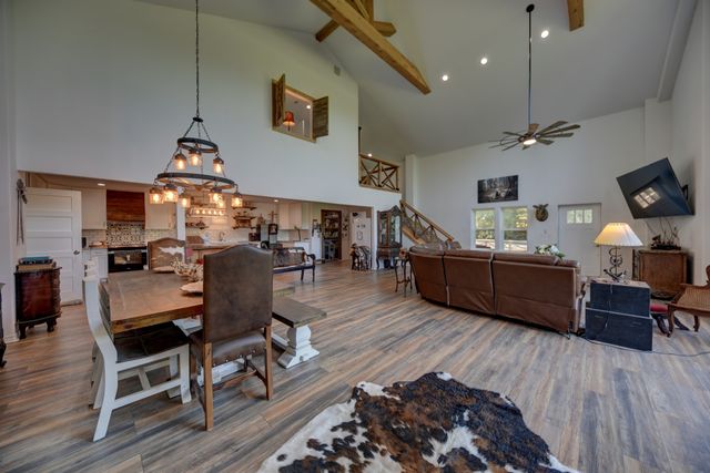 a kitchen with stainless steel appliances granite countertop a stove a sink dishwasher and a dining table with wooden floor