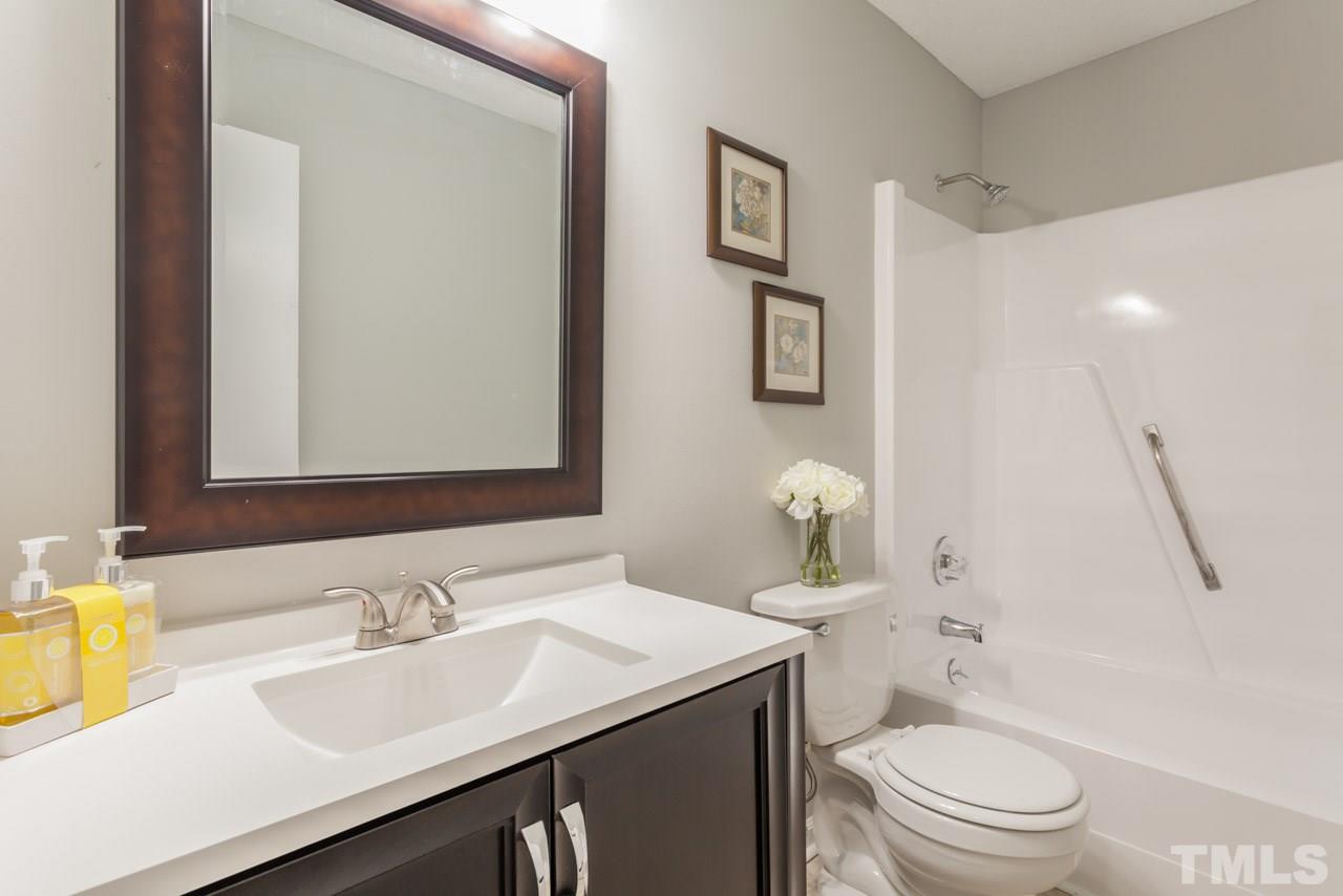 834 Horton Road Durham, NC 27704 - Photo 6 of 22 a bathroom with a sink toilet vanity and shower
