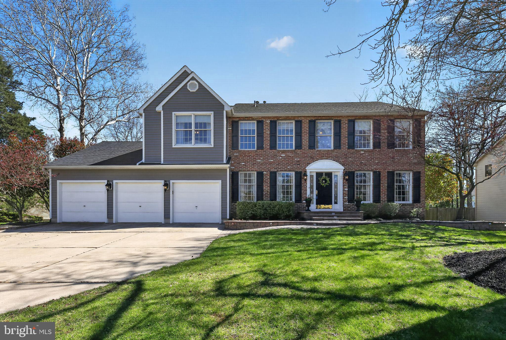 a front view of a house with a yard and trees