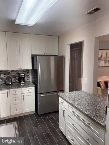 a kitchen with granite countertop a refrigerator and a sink
