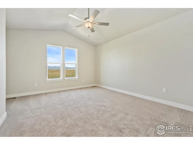 an empty room with fan and windows