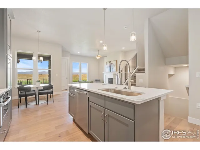 a kitchen with kitchen island a sink and a stove top oven with wooden floor