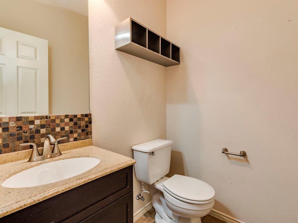 6 Verde Ranch Loop Leander, TX 78641 - Photo 19 of 24 Half bathroom featuring tasteful backsplash, vanity, and a textured wall
