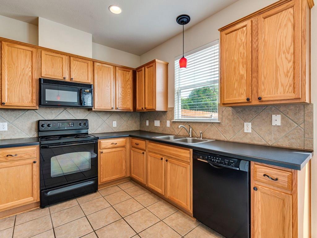 6 Verde Ranch Loop Leander, TX 78641 - Photo 9 of 24 a kitchen with granite countertop cabinets stainless steel appliances a sink and a window