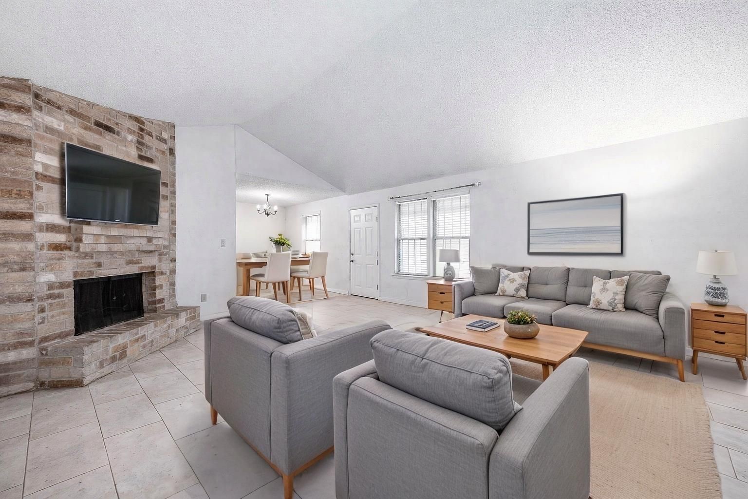 12703 Redfern Drive Houston, TX 77048 - Photo 2 of 15 a living room with furniture a fireplace and a flat screen tv