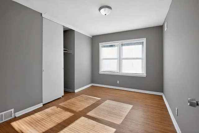 a view of an empty room with wooden floor