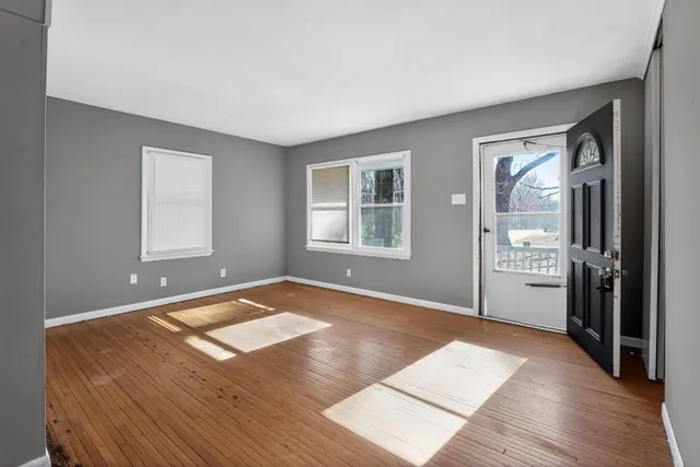 a view of a room with wooden floor and windows