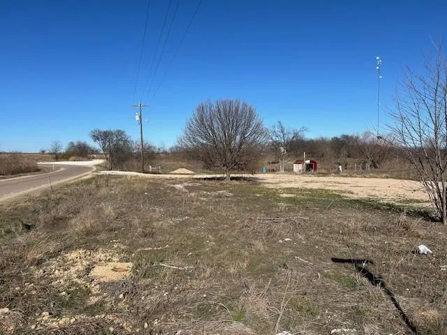 a view of dirt field with trees