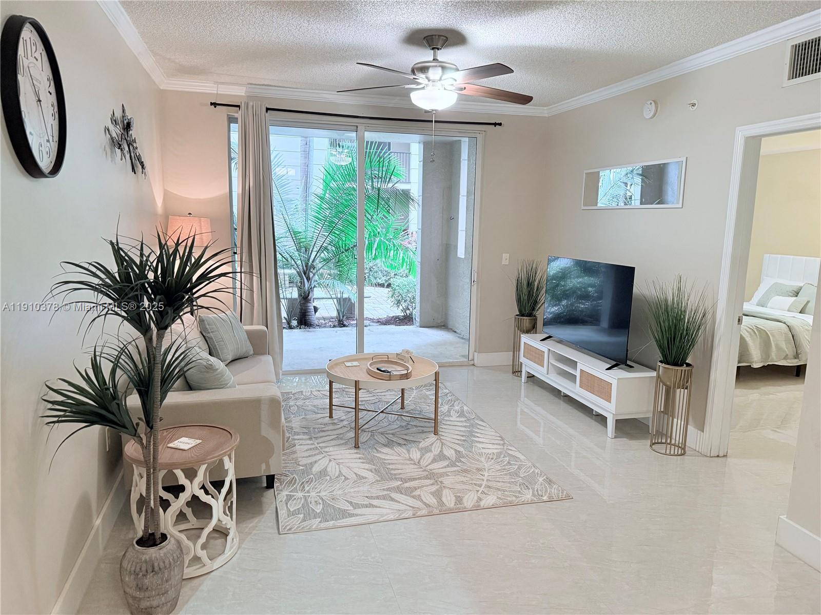 17150 North Bay Road, Unit 2102 Sunny Isles Beach, FL 33160 - Photo 1 of 29 a living room with furniture and a flat screen tv