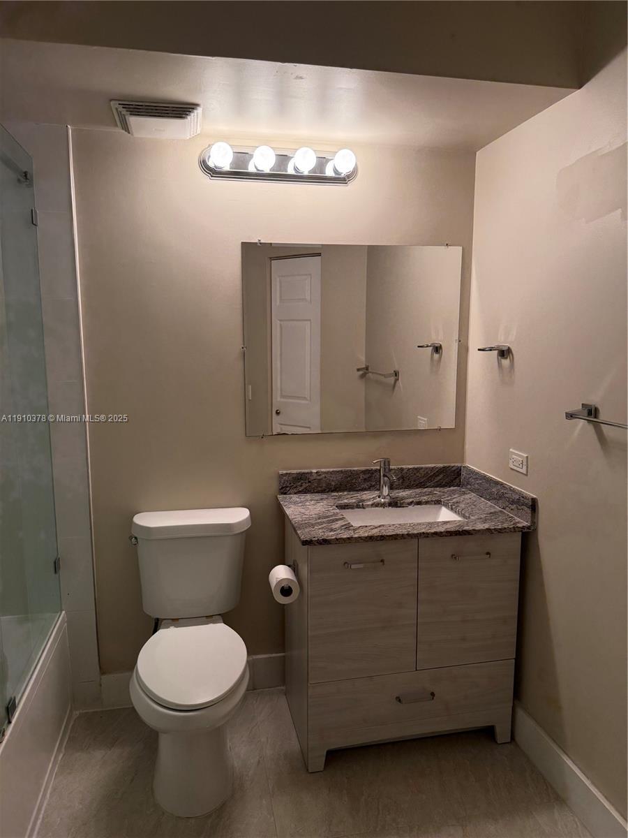 17150 North Bay Road, Unit 2102 Sunny Isles Beach, FL 33160 - Photo 17 of 29 a bathroom with a granite countertop toilet a sink and a mirror