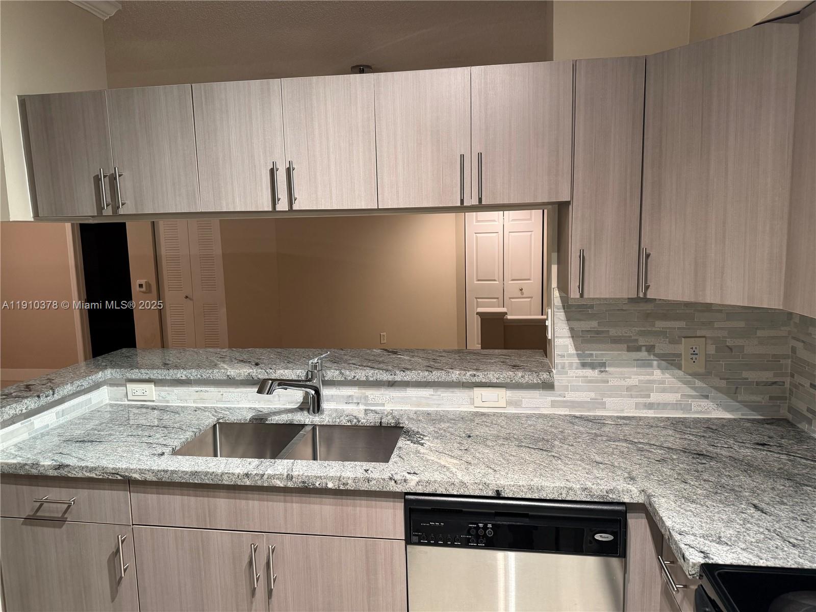 17150 North Bay Road, Unit 2102 Sunny Isles Beach, FL 33160 - Photo 5 of 29 a kitchen with granite countertop white cabinets and a sink