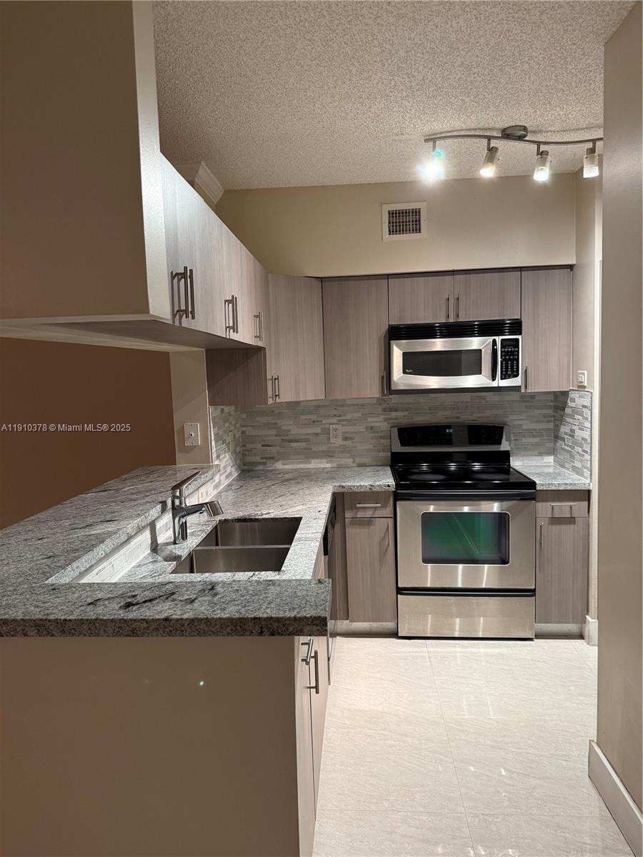 17150 North Bay Road, Unit 2102 Sunny Isles Beach, FL 33160 - Photo 6 of 29 a kitchen with stainless steel appliances granite countertop a sink and a stove