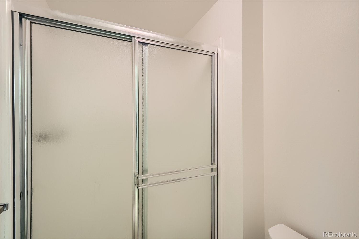 3398 East Easter Place Centennial, CO 80122 - Photo 17 of 28 a bathroom with a glass shower door