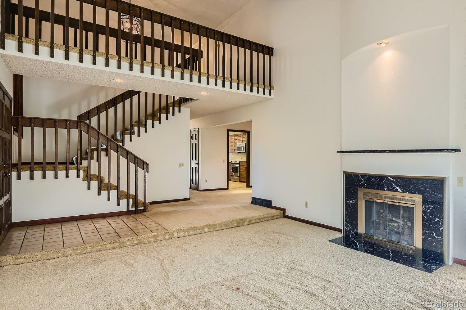 3398 East Easter Place Centennial, CO 80122 - Photo 4 of 28 a view of staircase with white walls and fireplace