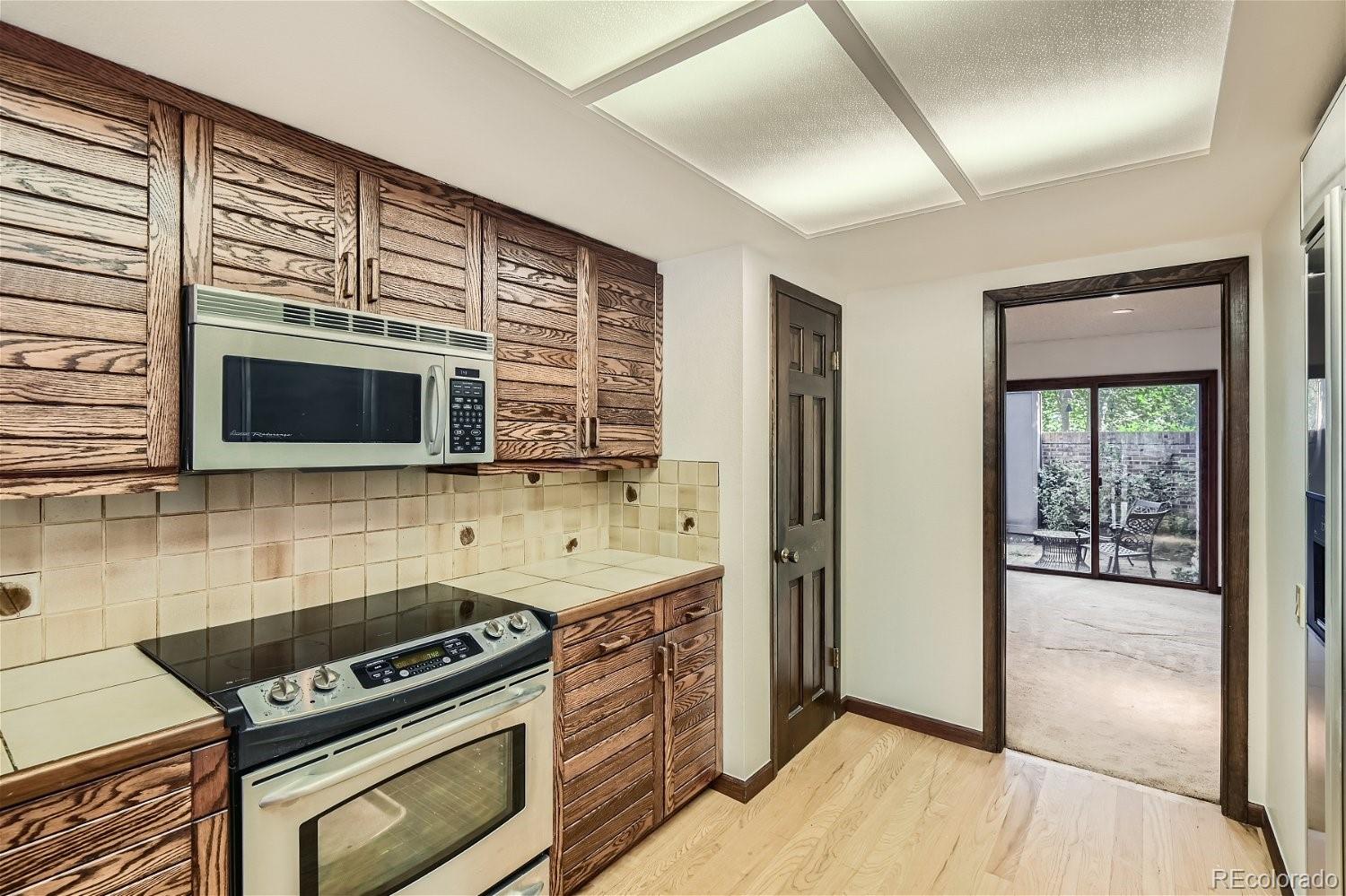 3398 East Easter Place Centennial, CO 80122 - Photo 7 of 28 a kitchen with stainless steel appliances a stove a microwave and a sink