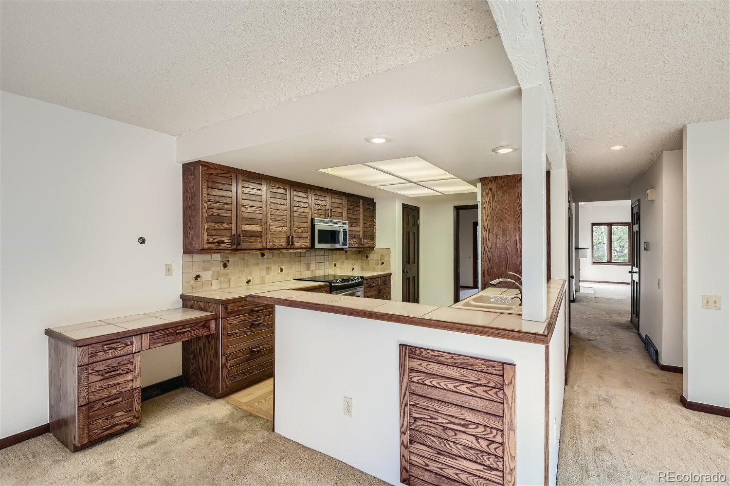 3398 East Easter Place Centennial, CO 80122 - Photo 8 of 28 a kitchen with stainless steel appliances kitchen island granite countertop a stove and a sink