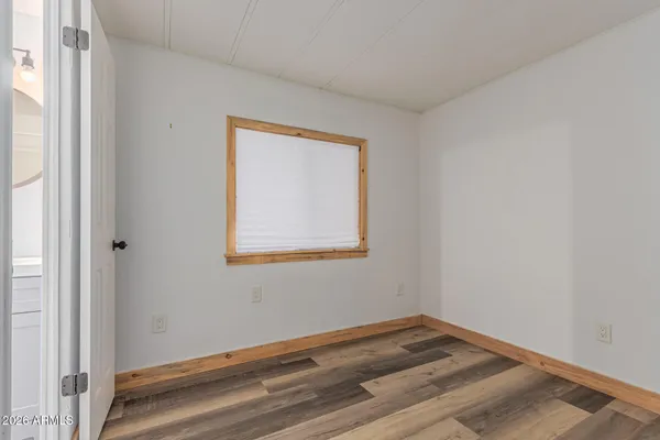 a view of empty room with wooden floor