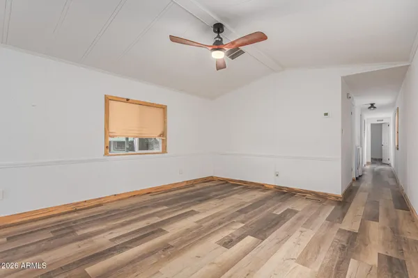 a view of a room with wooden floor and a ceiling fan