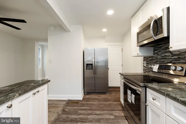 a kitchen with stainless steel appliances granite countertop a stove a refrigerator and a microwave