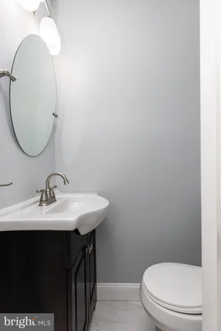 a bathroom with a sink a toilet and a mirror