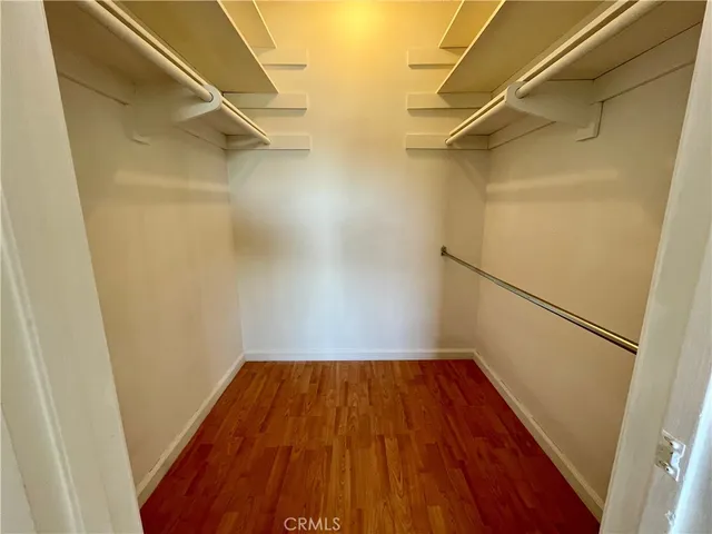 a view of walk in closet with wooden floor