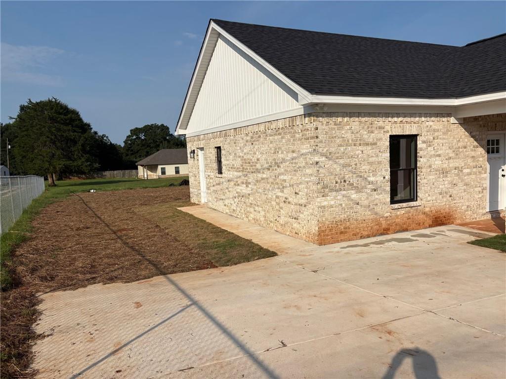 3216 South Phillips Road Lanett, AL 36863 - Photo 3 of 14 Light-colored brick exterior with a dark shingle roof and white soffit