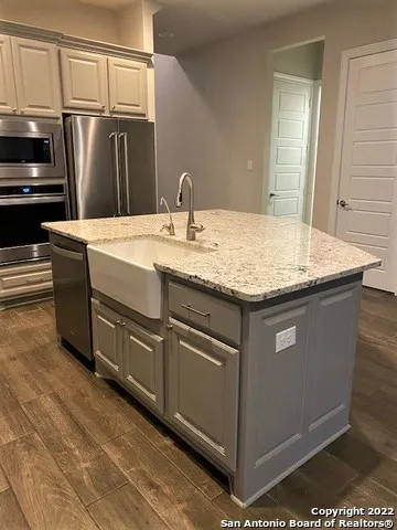 a kitchen with stainless steel appliances granite countertop a sink and a refrigerator