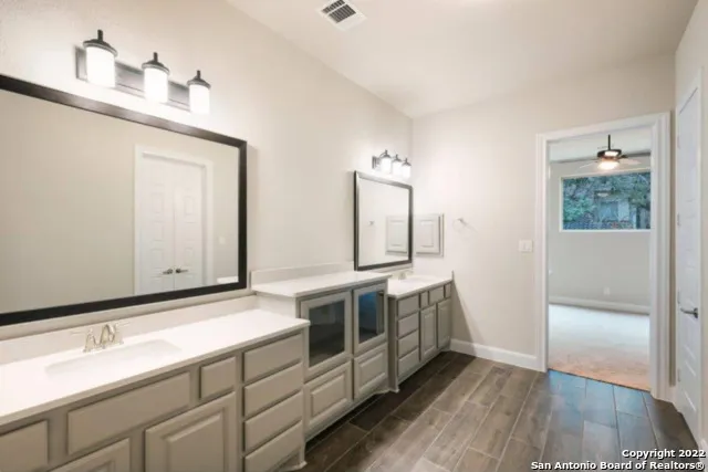 a spacious bathroom with a double vanity sink and a mirror