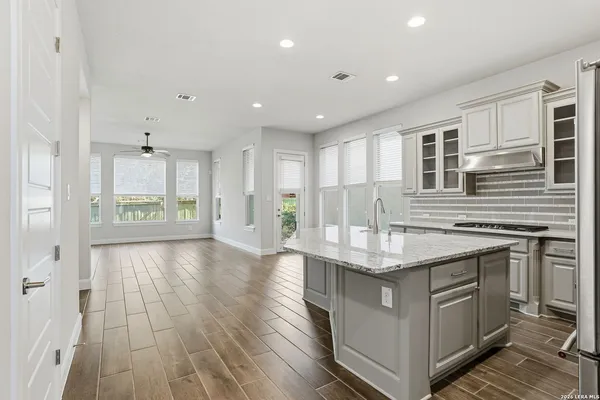 a kitchen with stainless steel appliances granite countertop a sink stove and cabinets
