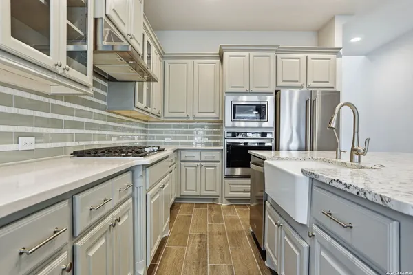 a kitchen with cabinets appliances a sink and a counter top space