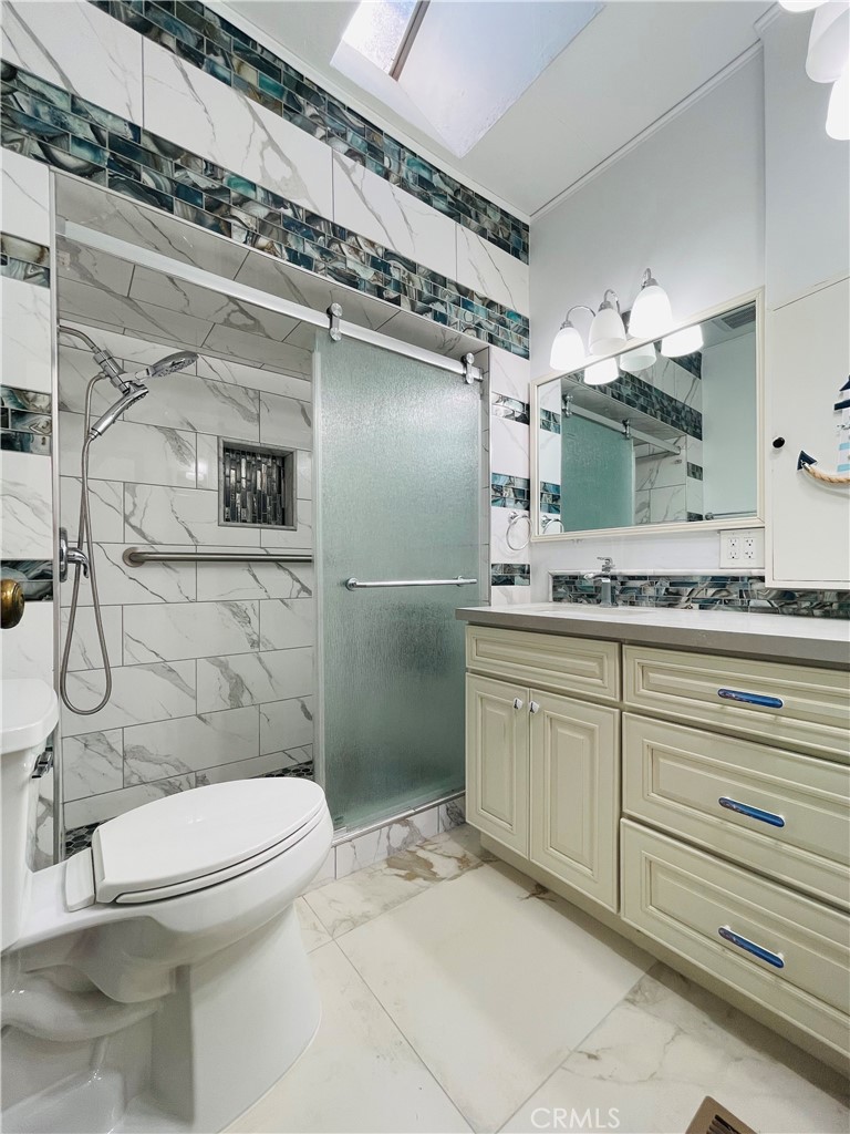 3225 Locust Street Riverside, CA 92501 - Photo 32 of 63 a bathroom with a granite countertop sink toilet and shower