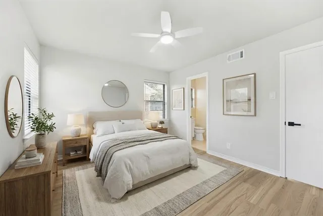 a spacious bedroom with a bed and a chandelier