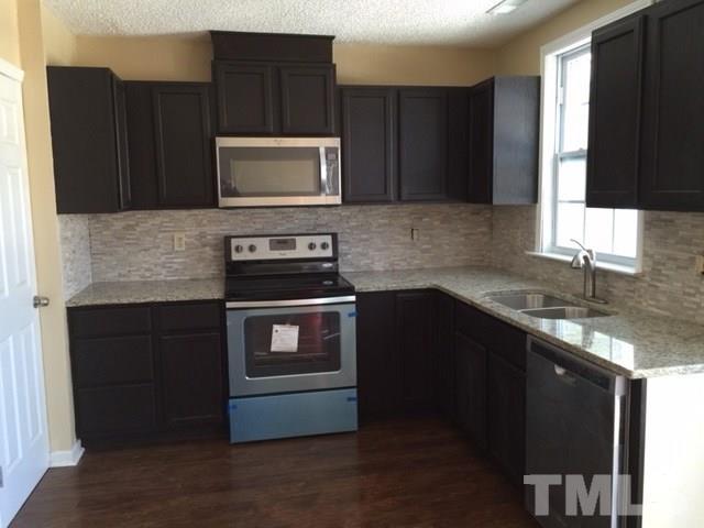 5109 Dice Drive Raleigh, NC 27616 - Photo 9 of 22 a kitchen with granite countertop a stove and a microwave