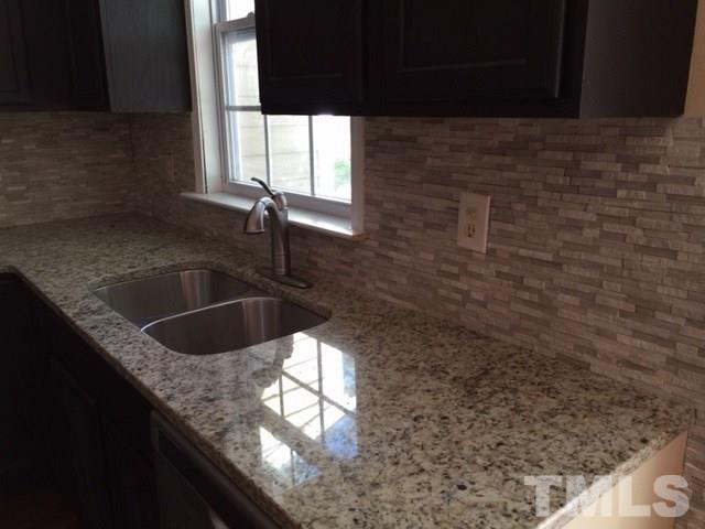 5109 Dice Drive Raleigh, NC 27616 - Photo 10 of 22 a kitchen with granite countertop a sink window and cabinets