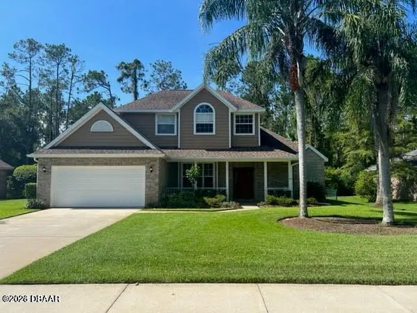 a front view of a house with a yard and trees