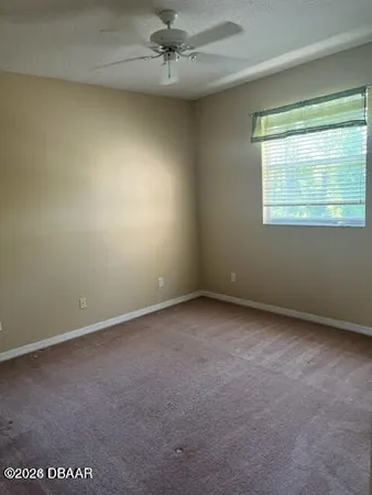 an empty room with a window and a fan