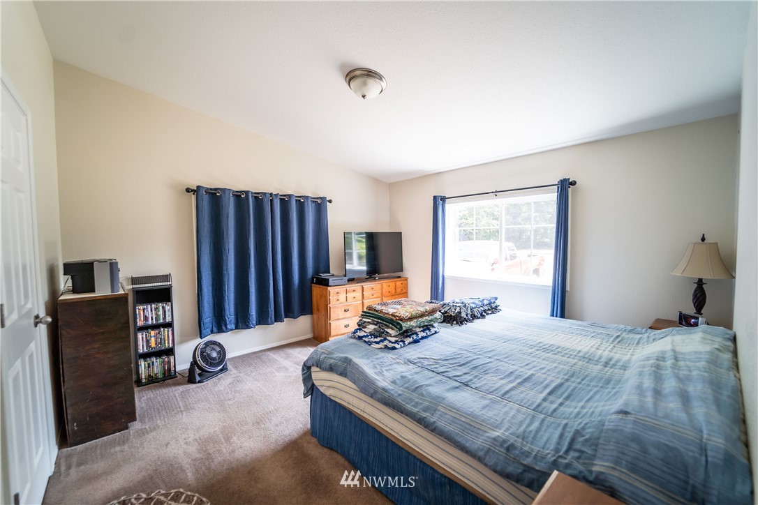 289 Antrim Road Winlock, WA 98596 - Photo 12 of 30 a bedroom with a bed and wooden floor