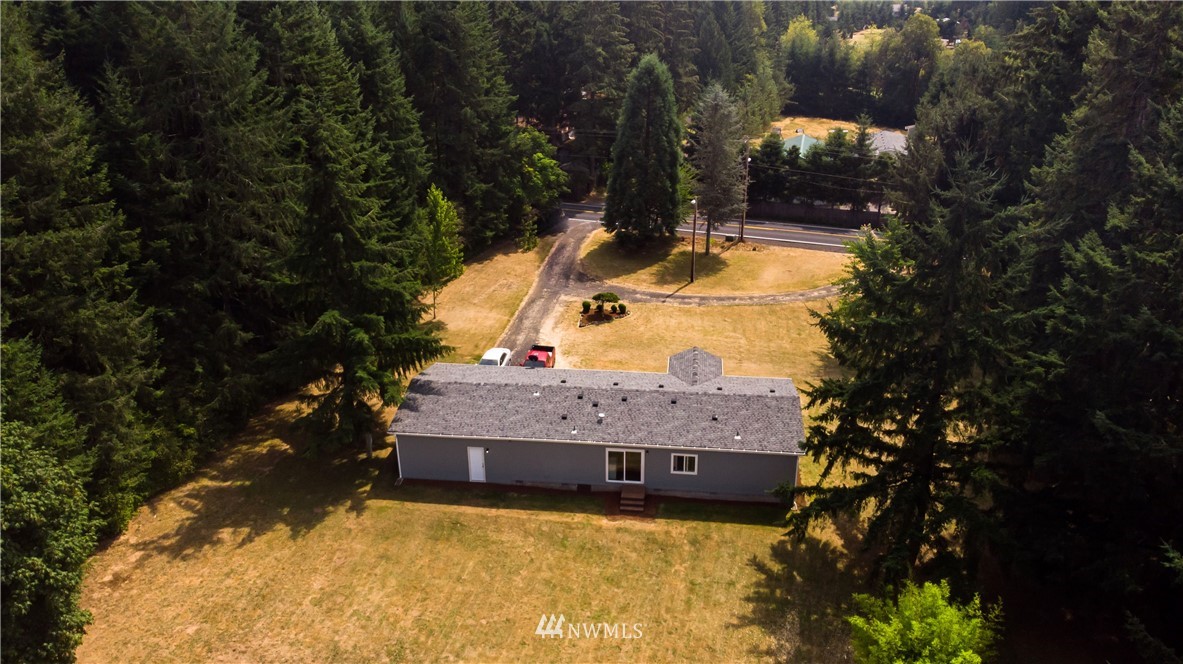 289 Antrim Road Winlock, WA 98596 - Photo 22 of 30 a view of a house with a yard large tree and a wooden fence