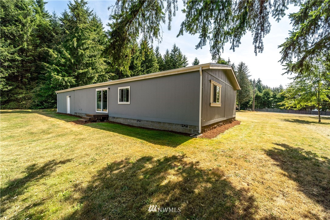 289 Antrim Road Winlock, WA 98596 - Photo 5 of 30 a backyard of a house with large trees and wooden fence
