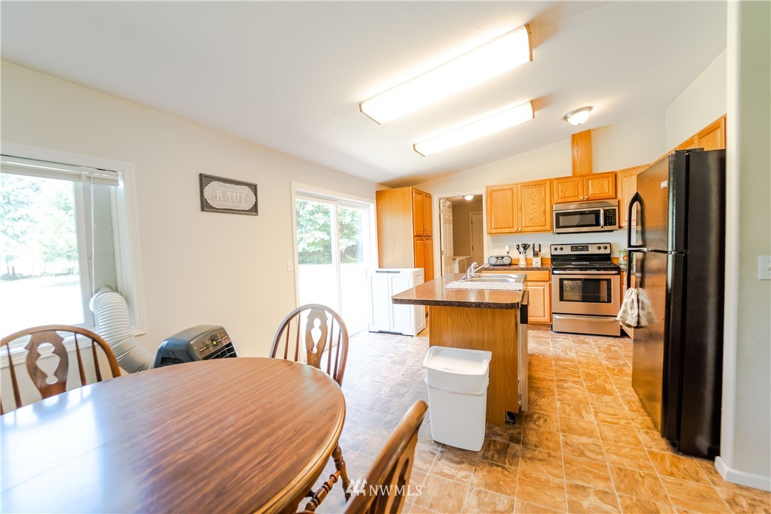 289 Antrim Road Winlock, WA 98596 - Photo 10 of 30 a kitchen with stainless steel appliances a stove a refrigerator a table and chairs