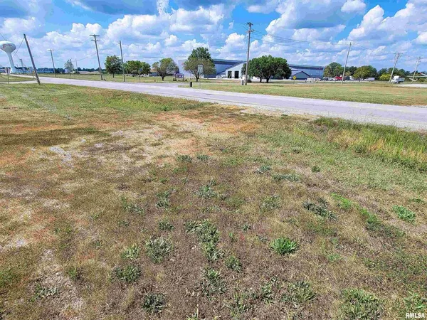 a view of a big yard with an empty space and a lake view