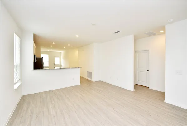 a view of kitchen with kitchen island a sink wooden floor and a refrigerator