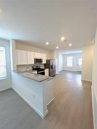 a view of kitchen with stainless steel appliances granite countertop a sink a stove and a window