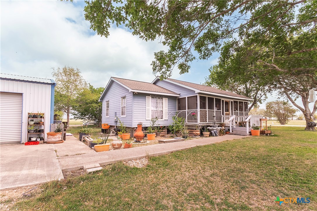 802 Bay Street Austwell, TX 77950 - Photo 3 of 27 a front view of a house with a garden and tree