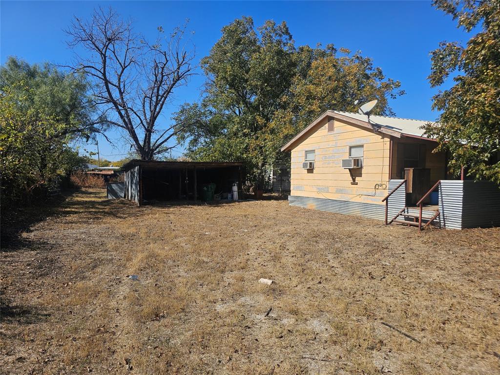 1008 Sixth Street Bangs, TX 76823 - Photo 14 of 24 a view of a house with a yard and large tree