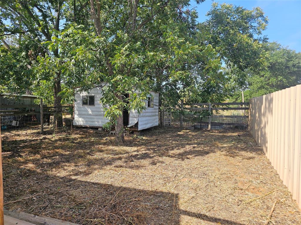 1008 Sixth Street Bangs, TX 76823 - Photo 16 of 24 a backyard of a house with a tree
