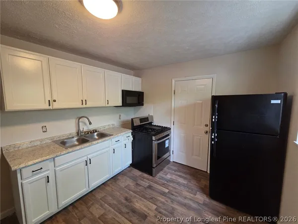 a kitchen with a refrigerator and a sink