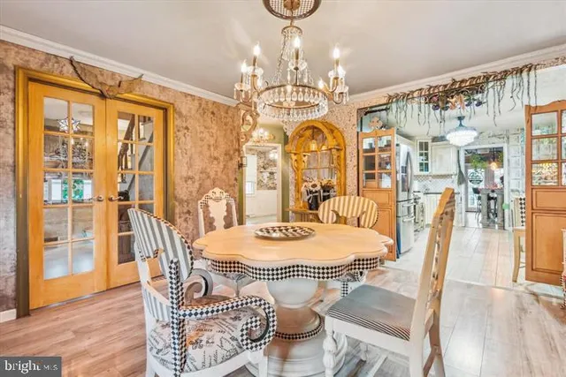 a dining room with furniture a chandelier and wooden floor